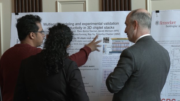 Three people looking at a presentation board